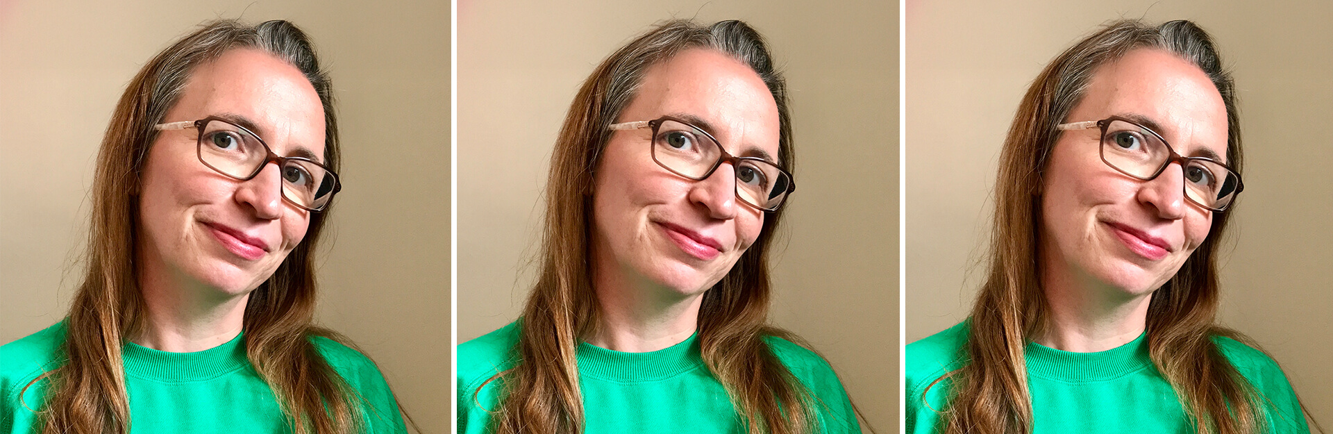 A woman with long hair and glasses smiles, wearing a green sweatshirt against a neutral background.