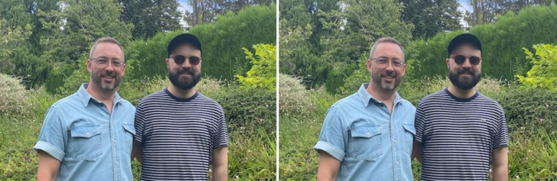 Two men stand side by side outdoors, smiling, with greenery in the background. One wears a denim shirt, the other a striped shirt.