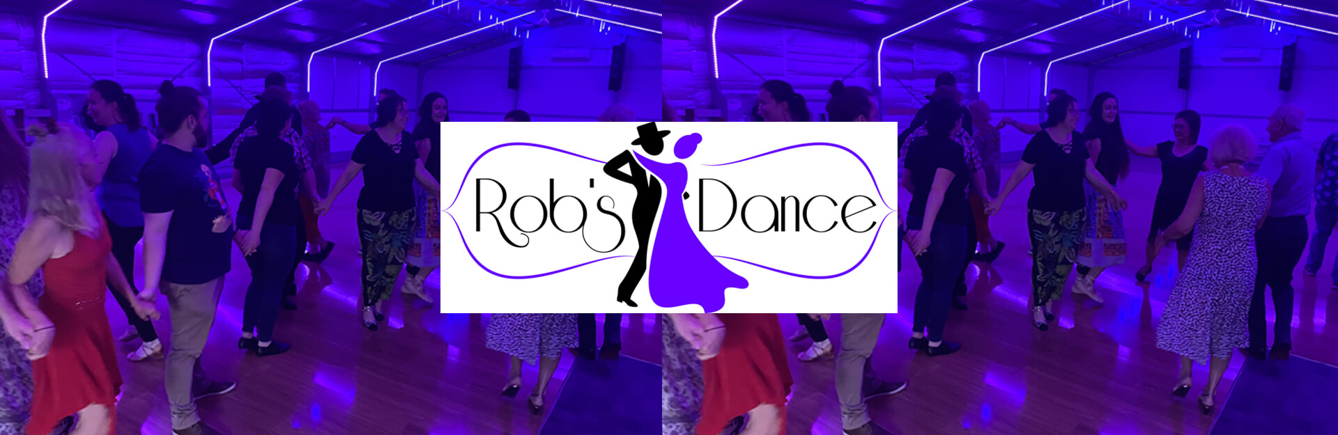 A group of people dancing in a brightly lit hall with purple lighting, featuring a logo for "Rob's Dance" in the center.