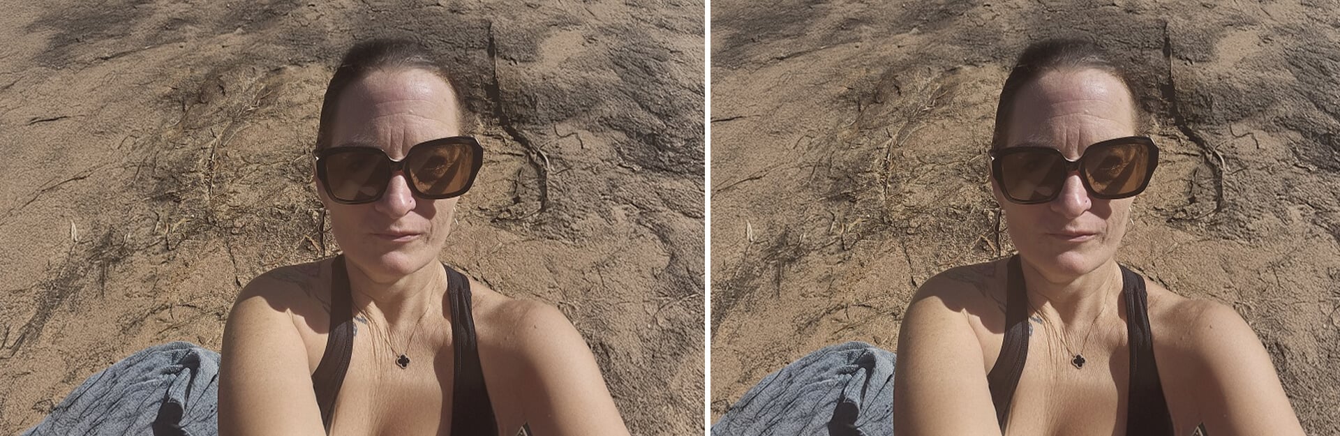 A person is sitting on sandy ground, wearing large sunglasses, with a neutral expression and a tank top.