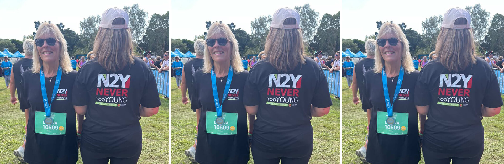 A woman with sunglasses and a medal wears a black shirt that reads "N2Y NEVER tooYOUNG" at an outdoor event.