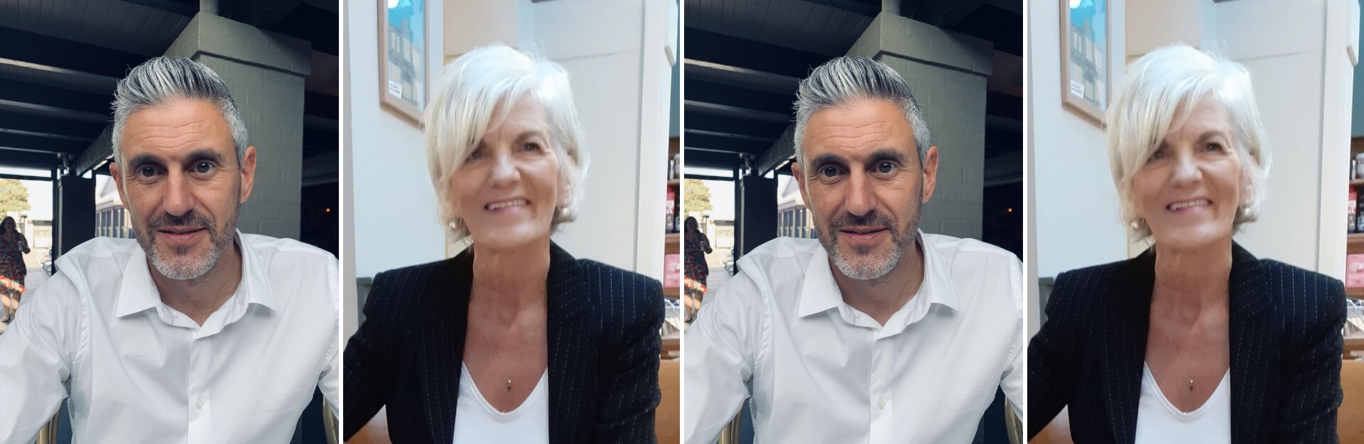 A man with grey hair and a beard sits at a table, next to a woman with short blonde hair, both smiling.