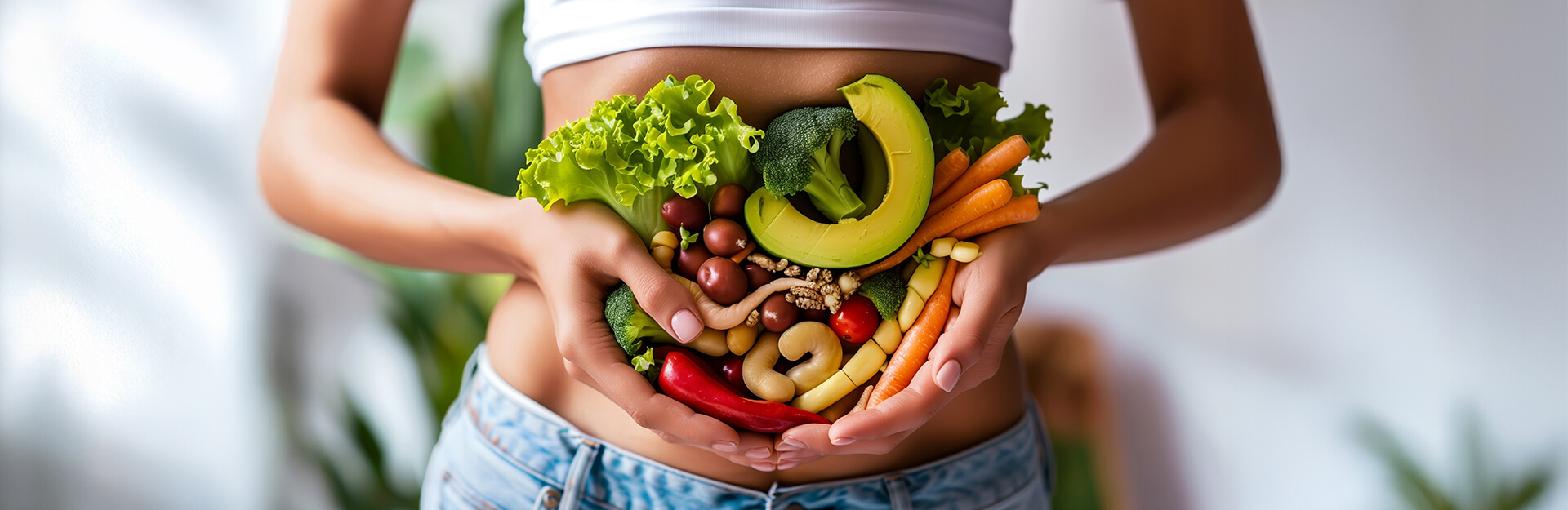 A person holding fresh vegetables and fruits in front of their abdomen, surrounded by greenery.