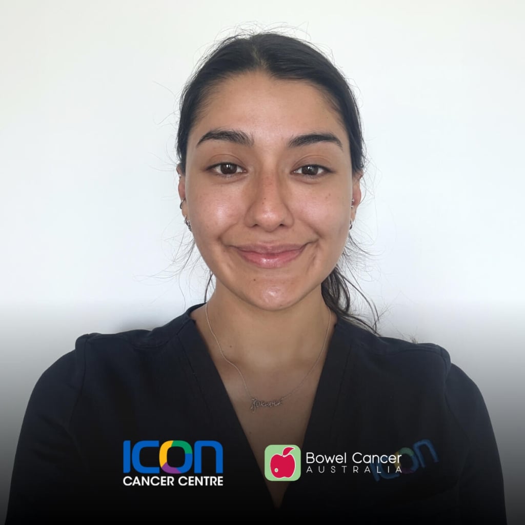 A smiling woman in a black shirt with logos for Icon Cancer Centre and Bowel Cancer Australia against a plain background.