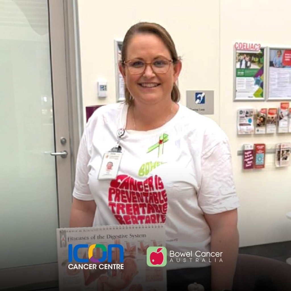 A smiling nurse in a white shirt holds educational materials about bowel cancer in a healthcare setting.